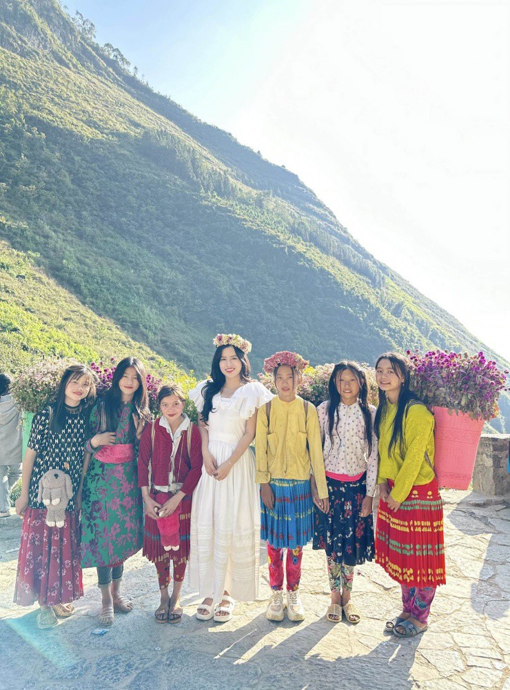 Du khách chụp hình cùng với các em bé nhỏ.