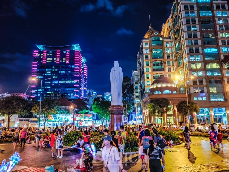Từ bên trong nhìn ra, bên dưới tượng Đức Mẹ Maria, nườm nượp các bạn trẻ hẹn hò nhau ra đây vãn cảnh, hàn huyên và hóng mát.