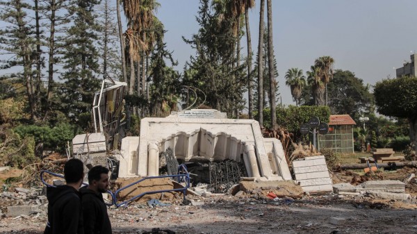 Người Palestine đi ngang một công viên bị phá hủy bởi các cuộc không kích của Israel ở thành phố Gaza