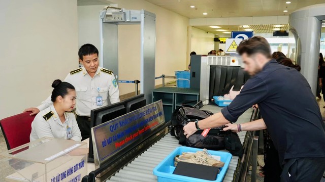 Anh Nguyễn Quốc Phong và đồng nghiệp - Đội An ninh soi chiếu quốc tế - Trung tâm An ninh hàng không Nội Bài đang theo dõi màn hình soi chiếu an ninh. Ảnh: NIA