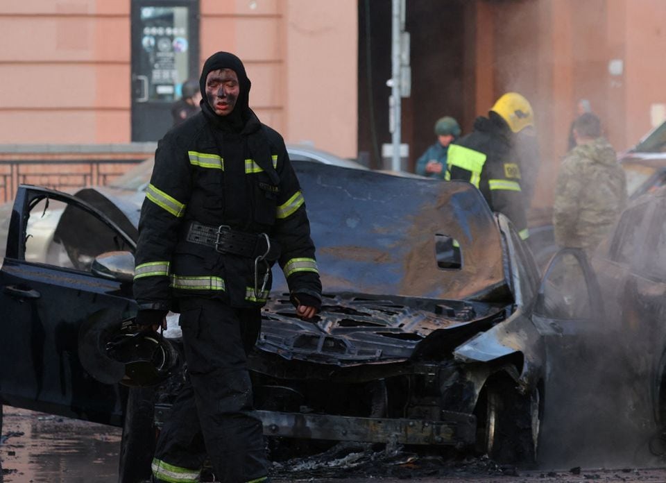 Một nhân viên cứu hỏa Nga đi qua một chiếc ô tô bị cháy rụi sau vụ Ukraine tấn công ở thành phố Belgorod ngày 30/12/2023. Ảnh: Reuters