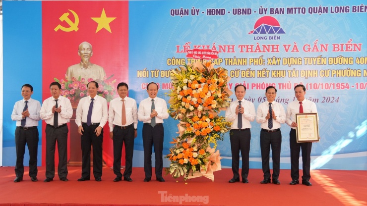 Các đại biểu lãnh đạo thành phố Hà Nội, quận Long Biên cắt băng khánh thành, gắn biển công trình chào mừng kỷ niệm 70 năm Ngày Giải phóng Thủ đô với tuyến đường 40m nối từ đường Nguyễn Văn Cừ đến hết khu tái định cư phường Ngọc Thụy. Ảnh: Hoàng Mạnh Thắng.