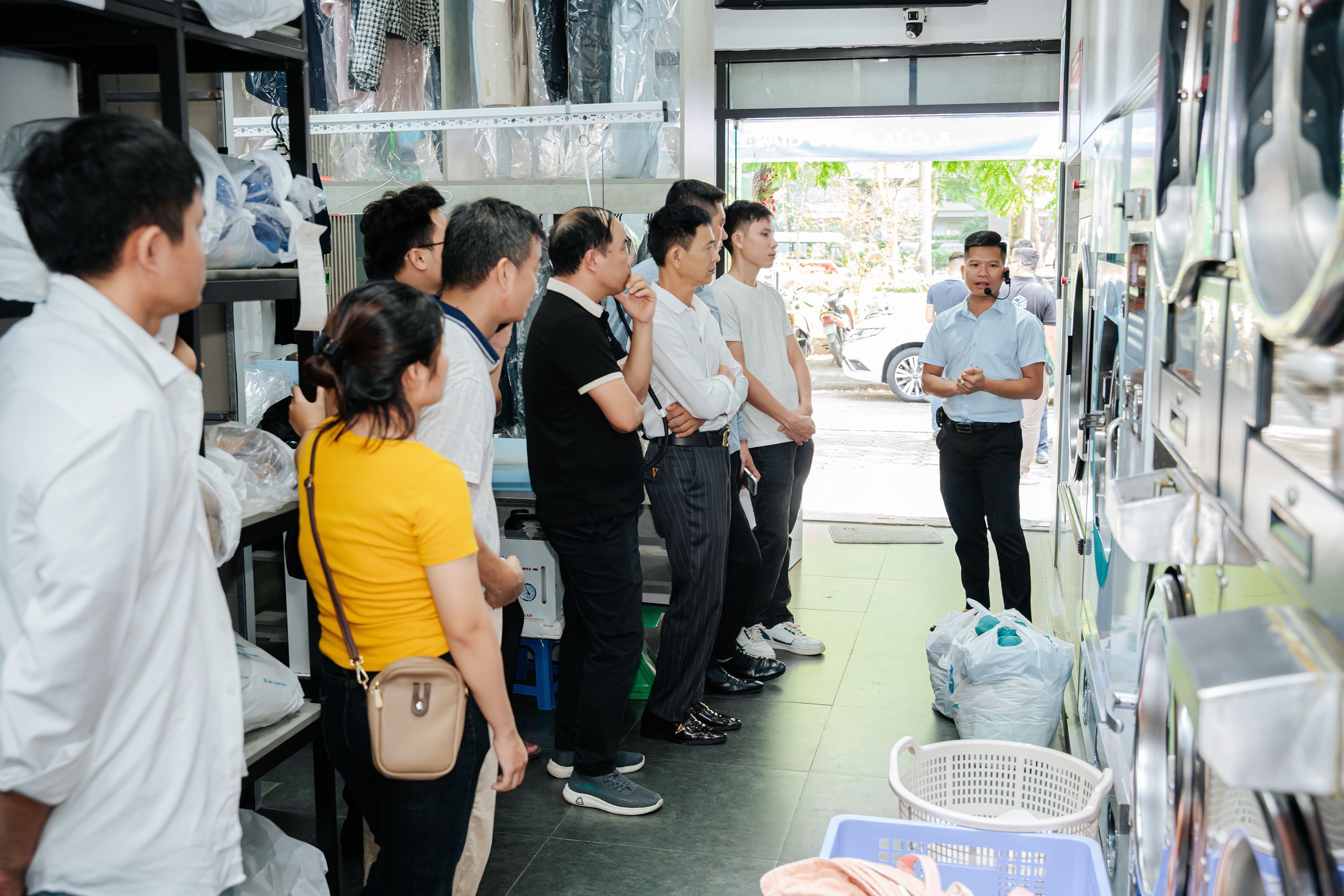 Ông Phạm Văn Huy - PGĐ Kinh Doanh Asiatech Việt Nam dẫn đoàn tham quan cửa hàng Giặt Là Sạch Cộng và Trung Tâm Đào Tạo Kinh Doanh Giặt Là.