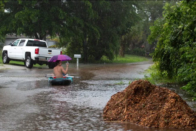 A man takes advantage of a break in the rain during Hurricane Milton to kayak on a flooded road. Photo: USA TODAY