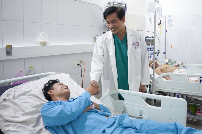 Bác sĩ Hà Sơn Bình chúc mừng anh Hùng đã qua cơn nguy kịch. Ảnh: Nguyễn Đông