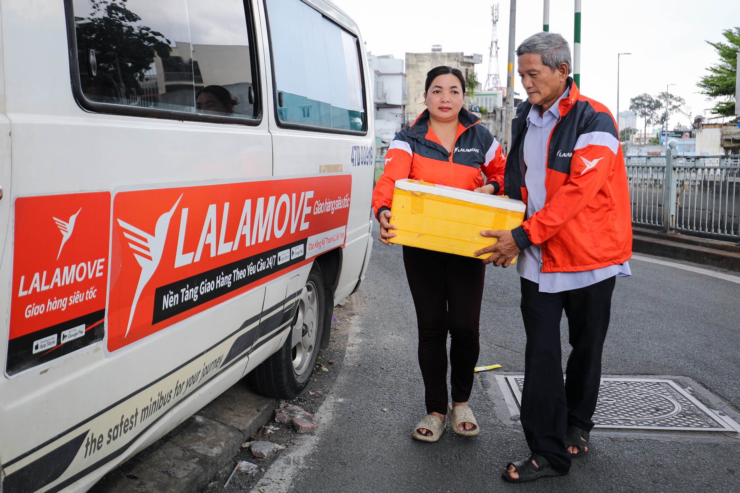 Chiếc xe tải van với logo màu cam Lalamove gắn bó với hai vợ chồng cùng bao chuyến hàng.