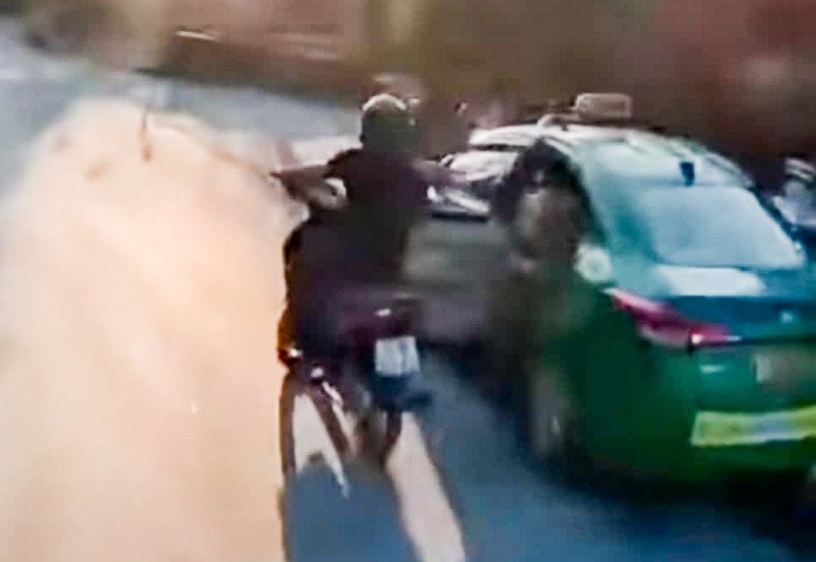 Taxi mở cửa va vào xe máy, khiến người điều khiển xe máy ngã ra đường. Ảnh: Cắt từ video