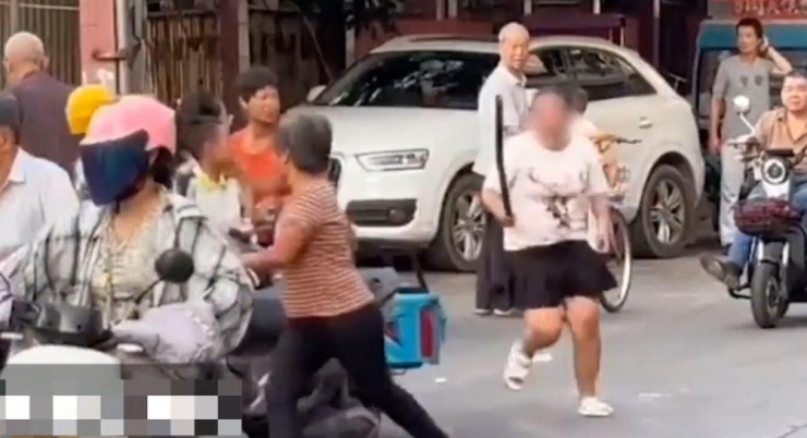 Cô gái rượt đánh người bán hoa quả trên phố.