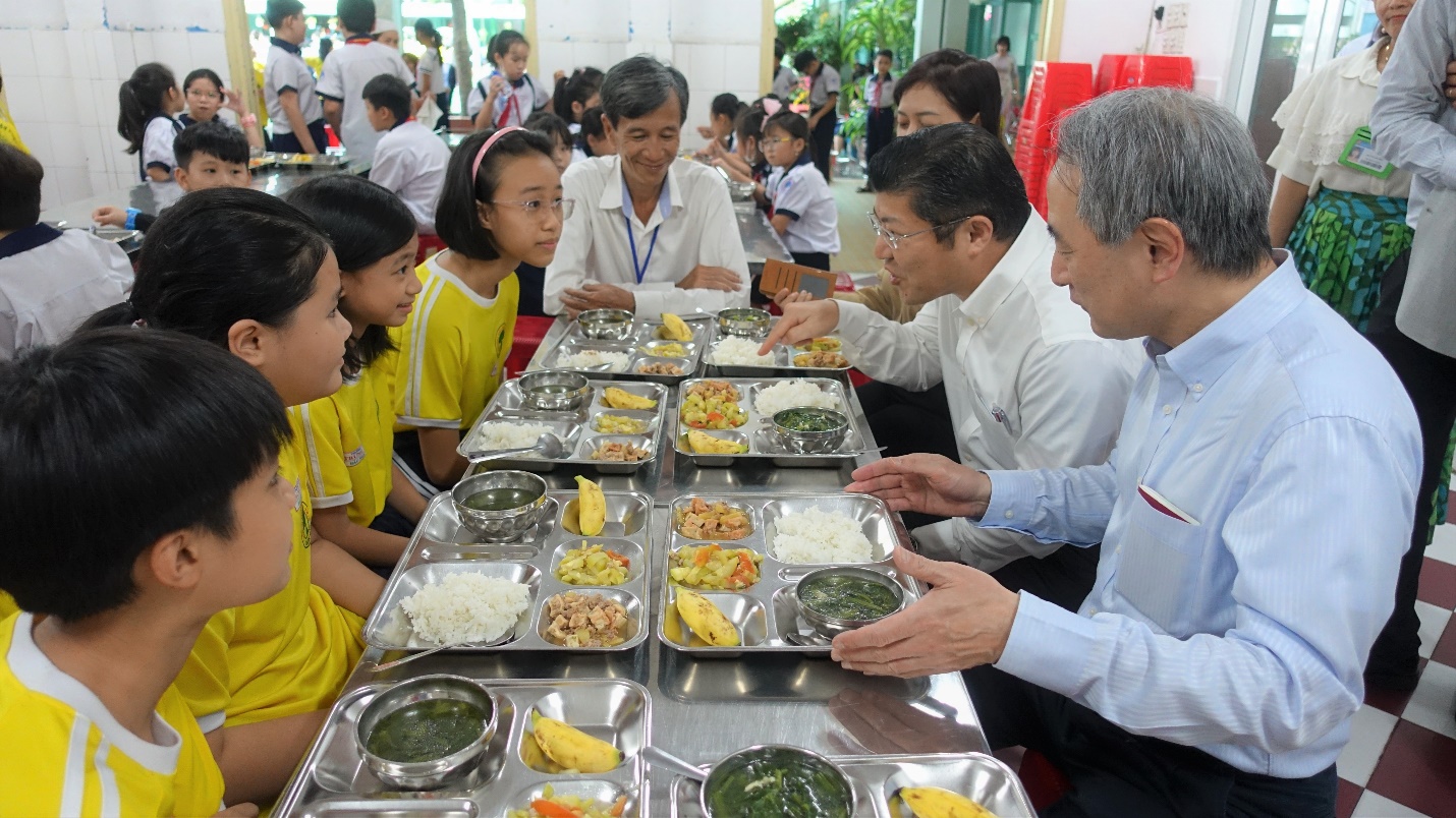 Ông Tsutomu Nara thưởng thức bữa trưa từ dự án Bữa ăn học đường do Ajinomoto Việt Nam triển khai cùng các em học sinh tiểu học.