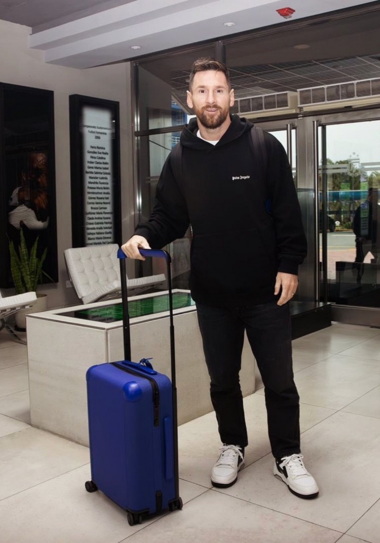 Lần khác về Argentina chuẩn bị cho các giải đấu lớn, anh chọn áo chui đầu, mix-match với quần denim đồng điệu, nhấn vào vali xanh dương.