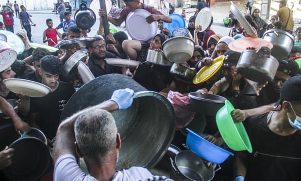 Người dân ở phía bắc Gaza chen nhau nhận lương thực cứu trợ hồi tháng 7/2024. Ảnh: Xinhua