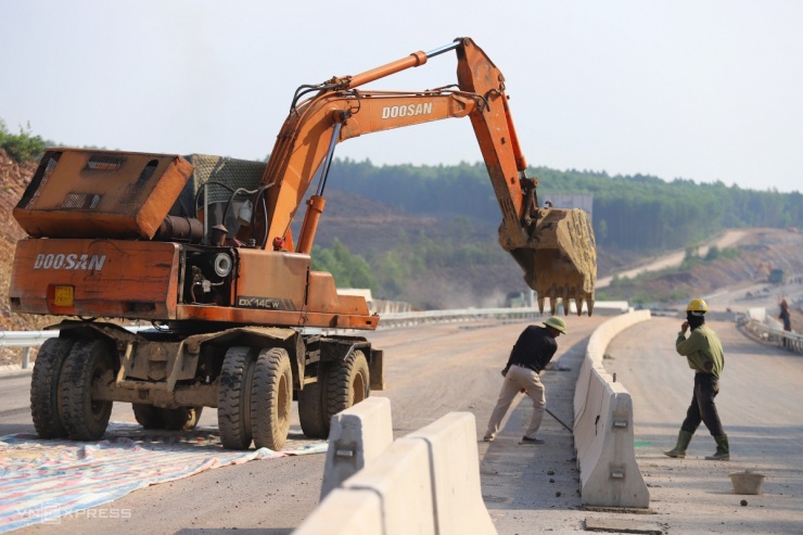 Công nhân, máy móc đang làm dải phân cách cứng giữa đường đoạn giáp ranh tỉnh Hà Tĩnh với Quảng Bình.
