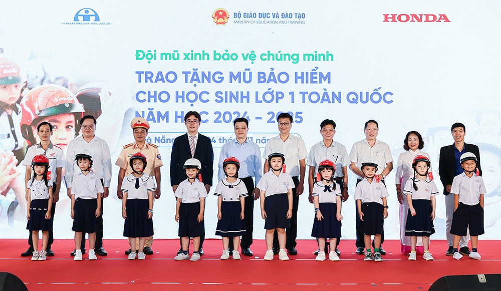 Các đại biểu trao tặng mũ bảo hiểm cho các em học sinh lớp Một trường Tiểu học Tiểu La (quận Sơn Trà)