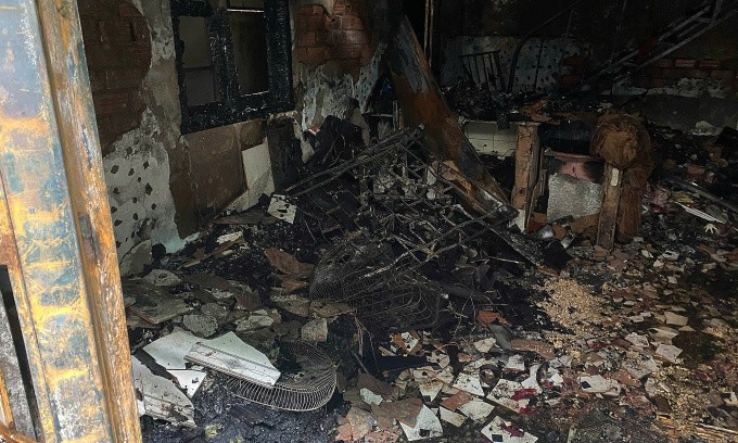 Nhiều vật dụng ở khu vực phòng khách bị lửa thiêu rụi, tường bong tróc từng mảng lớn. Ảnh: Minh Bằng