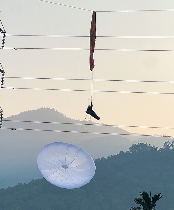 Dây dù vướng vào đường dây điện cách mặt đất khoảng 30 m. Ảnh: G.C.