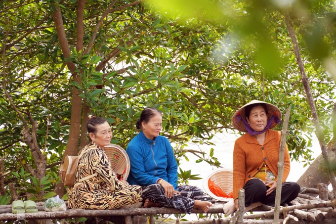 Bà Võ Thị Thu cùng các phụ huynh khác ngồi chờ con, cháu tan học. Ảnh: Chúc Ly