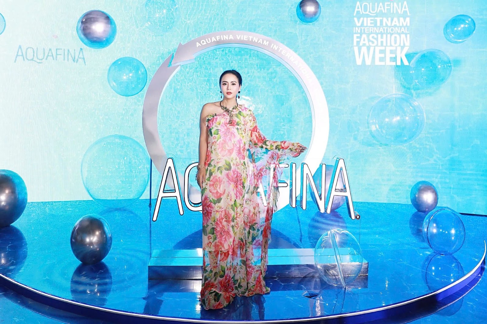 Chiếc đầm họa tiết bồng bềnh tôn dáng cùng với phụ kiện vòng cổ hợp gu thời trang của nữ doanh nhân chiếm trọn spotlight 