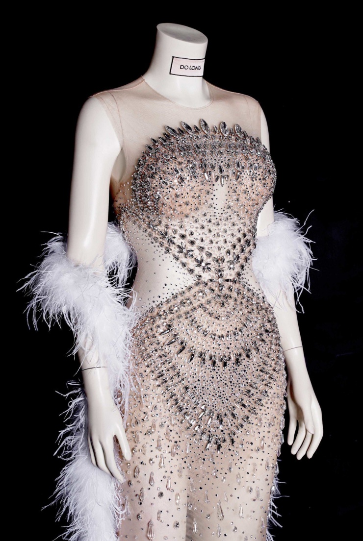 NTK Đỗ Long cho hay bộ đầm được thực hiện trong khoảng một tháng, đính kết hàng nghìn viên đá và pha lê trên nền lưới xuyên thấu để tạo hiệu ứng bắt sáng. Khoảng cut-out trước ngực và bên eo cũng khiến vòng hai trông nhỏ nhắn và tổng thể khêu gợi hơn.