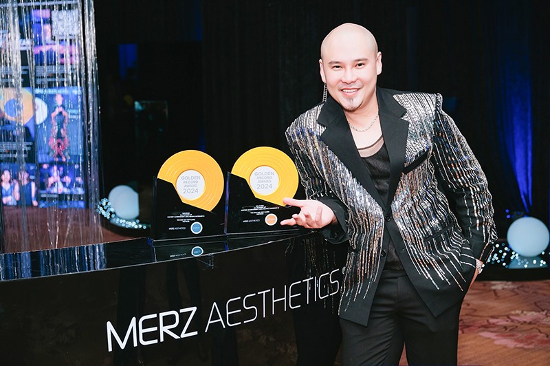 Bác sĩ Hoàng Thiên Minh Trị cùng 2 chiếc cúp danh giá của Merz Aesthetics.