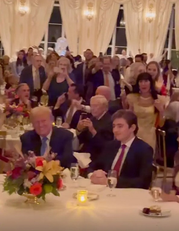 Barron ngồi cạnh cha tại tiệc lễ Tạ ơn. Ảnh cắt từ video