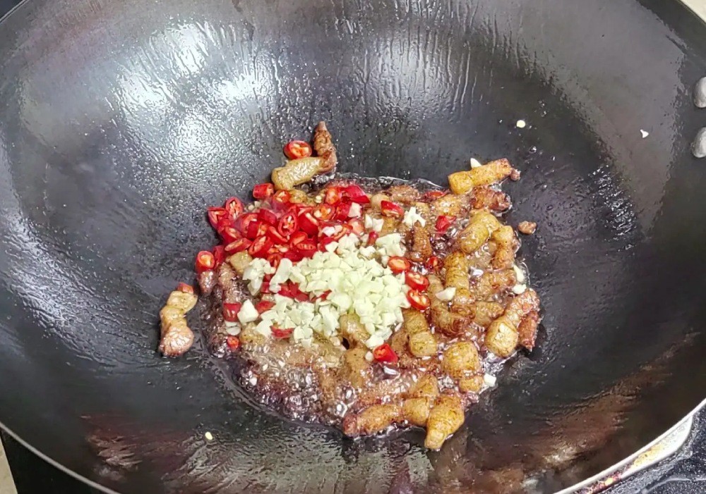 Cho tỏi băm và ớt vào chảo, xào ở nhiệt độ cao khoảng 15 giây.