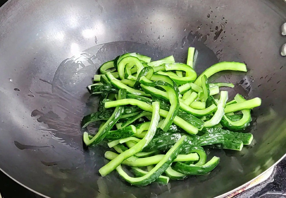 Đun nóng chảo, cho 15g dầu ăn vào, sau đó cho dưa chuột vào xào một chút. Mục đích chính của việc xào là để làm khô bớt nước trong dưa chuột. Như vậy, dưa chuột sẽ hấp thụ được dầu và hương vị từ thịt ba chỉ và gia vị thấm hơn.