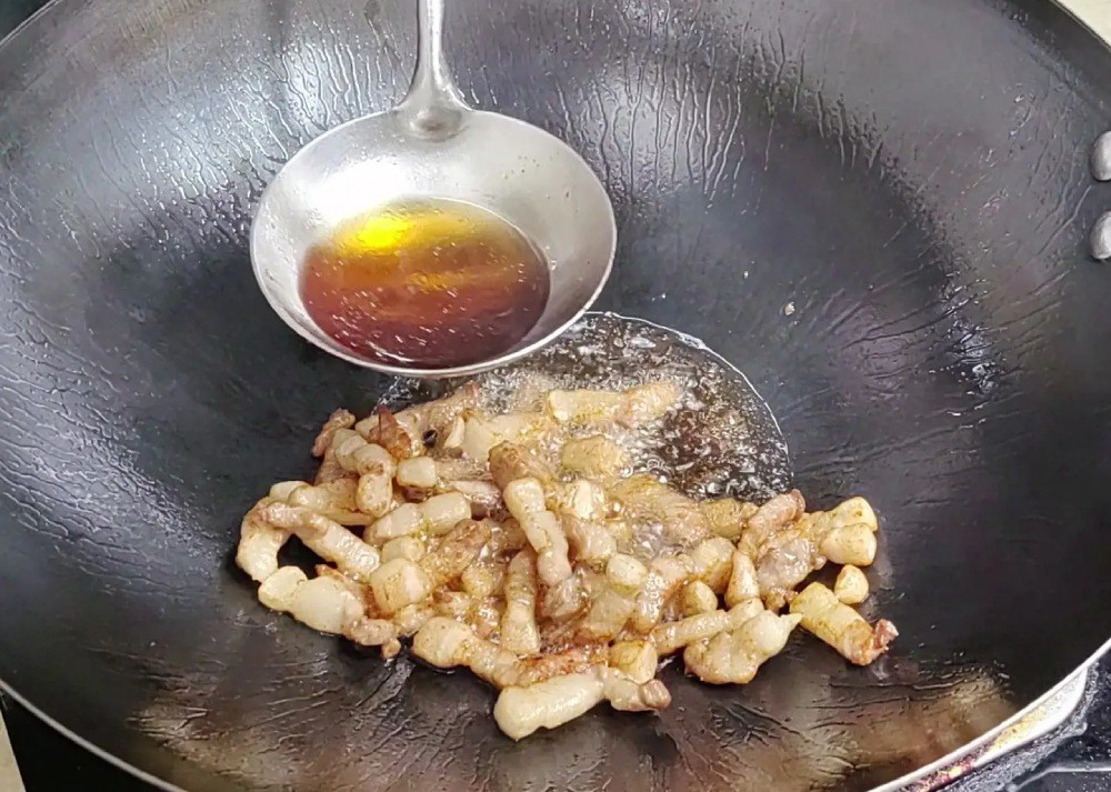 Trong chảo, cho 20g dầu ăn, khi dầu nóng thì cho thịt ba chỉ vào xào, xào ở nhiệt độ thấp từ từ làm cho mỡ trong thịt ba chỉ chảy ra, để tạo hương vị thơm cho thịt. Tiếp tục xào thịt ba chỉ cho đến khi săn lại, bề ngoài vàng đều, sau đó cho 20g rượu nấu ăn vào để khử mùi và tăng hương vị. Sau đó cho 3g xì dầu vào, đảo đều.