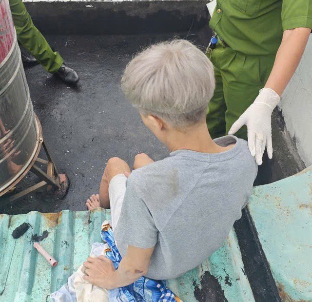 Thanh niên N.H được cảnh sát đưa xuống đất an toàn.