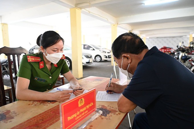 Cán bộ công an xã ở Hà Nội hướng dẫn người dân làm thủ tục cấp biển số xe máy. Ảnh: Gia Chính