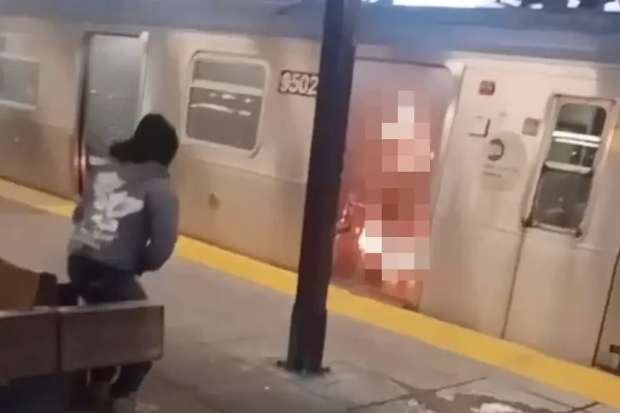 Nghi phạm trong vụ thiêu chết người trong tàu điện ngầm ở New York (Mỹ) đứng dậy rời đi sau một lúc ngồi nhìn lực lượng an ninh cố dập lửa. Ảnh: NEW YORK POST