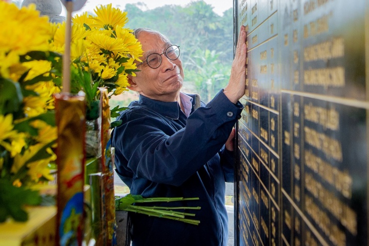 Thầy Nguyễn Xuân Khang xúc động khi nhìn tấm bảng ghi tên những người dân Làng Nủ bị thiệt mạng trong trận lũ.