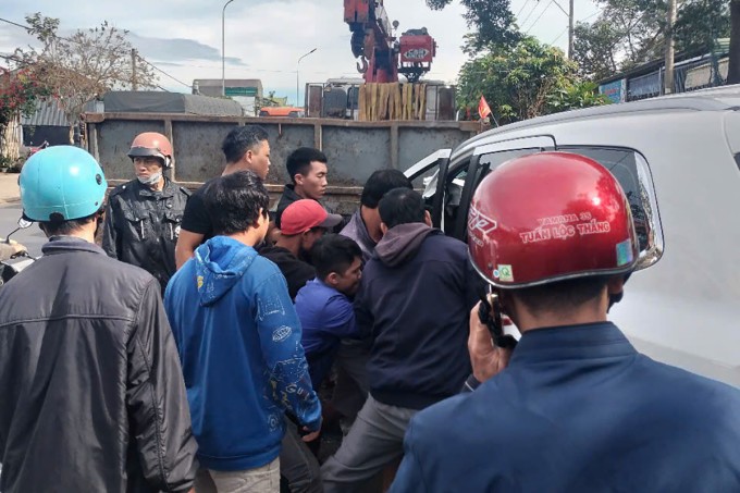 Người dân phá cửa đưa tài xế mắc kẹt ra ngoài. Ảnh: Hoài Thanh