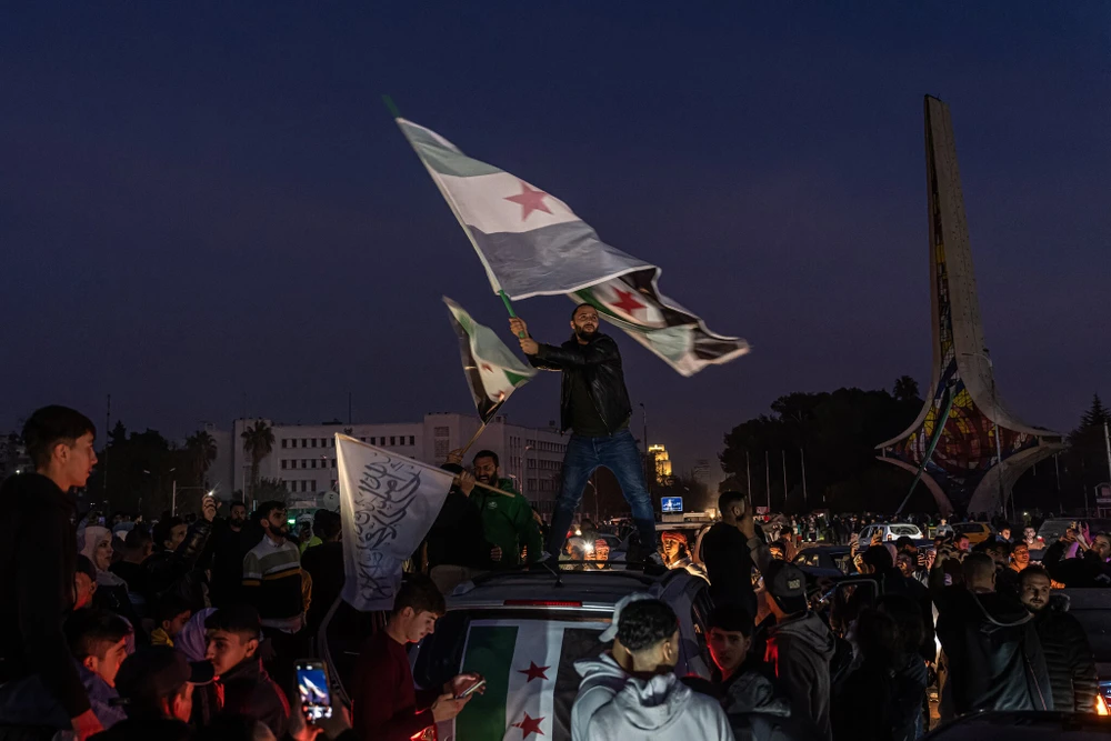 Lực lượng đối lập Syria ăn mừng ở thủ
đô Damascus (Syria) sau khi lật đổ chính quyền Tổng thống Bashar
al-Assad. Ảnh: THE NEW YORK TIMES