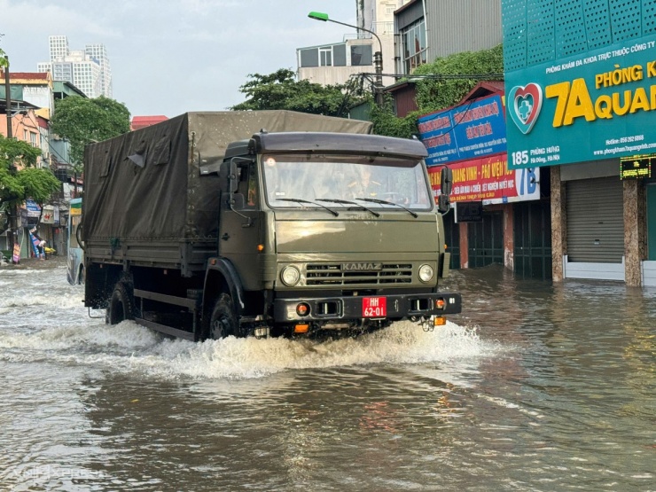 Xe quân đội qua đoạn nước sâu trên đường Phùng Hưng, Hà Đông. Ảnh: Ngọc Thành