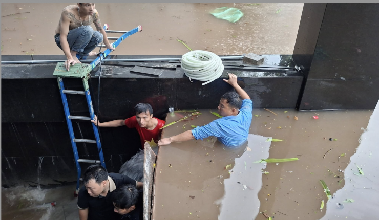 Dù ra sức chặn nhưng không ngăn được nước tràn vào hầm gửi xe. 