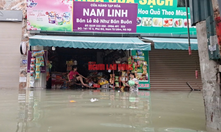 Người dân lội nước đi mua nhu yếu phẩm. Ảnh: Văn Duẩn