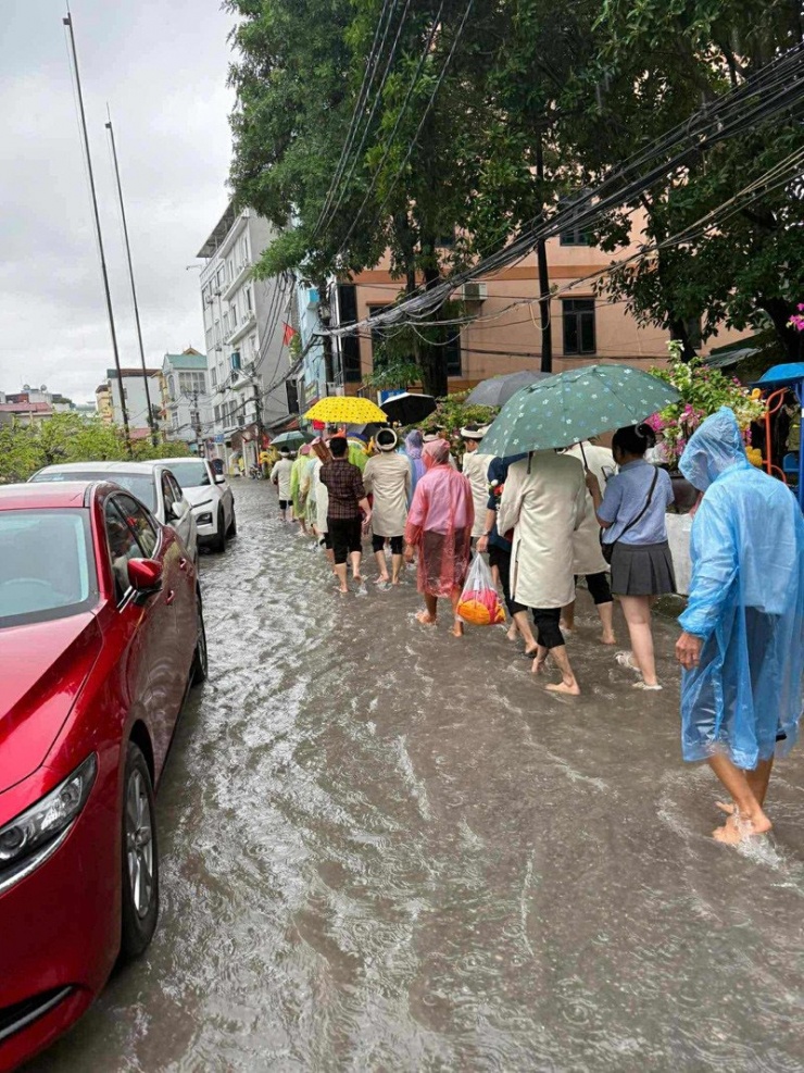Nhà trai mặc áo mưa, che ô, lội nước đi đón dâu 