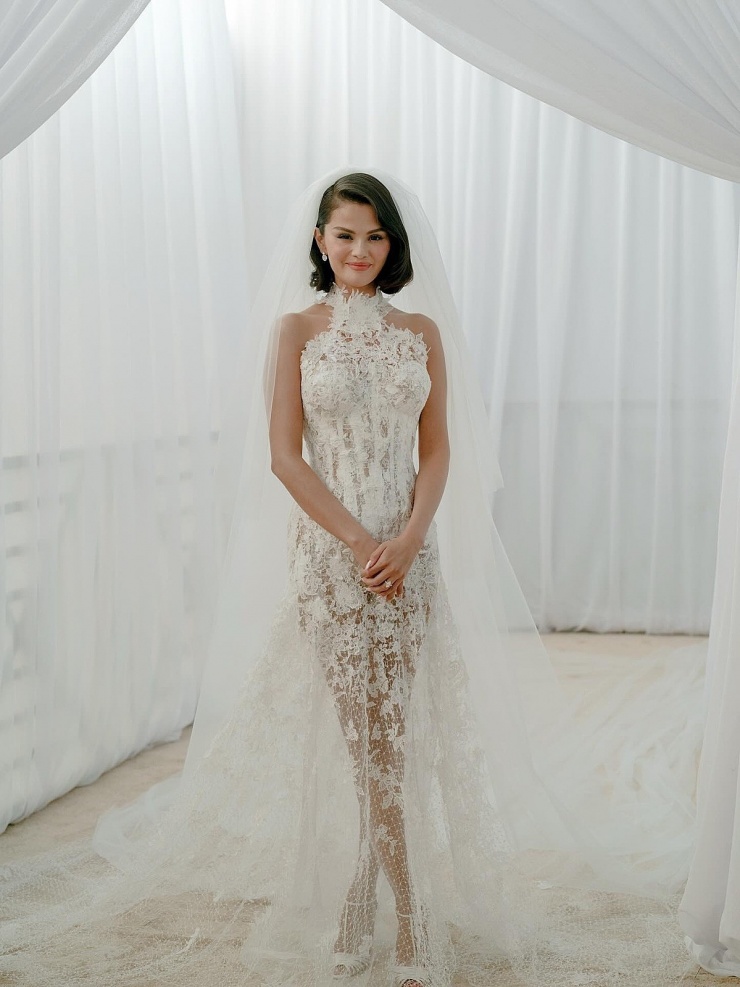 Selena Gomez mặc đầm ren trong lễ chính. Theo nhà mốt, bộ váy được đính thủ công 300 họa tiết bông hoa, đính pha lê trên phần corset và thêu tên viết tắt của cặp uyên ương và ngày cưới.