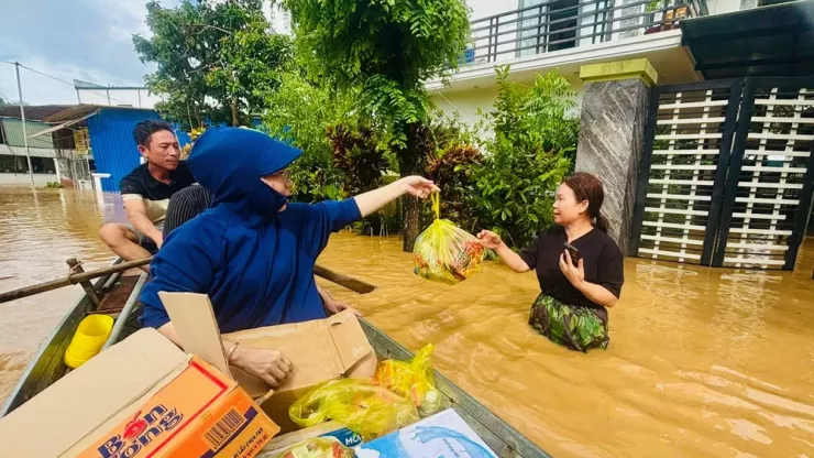 Người dân lội nước lũ ra nhận mì tôm.