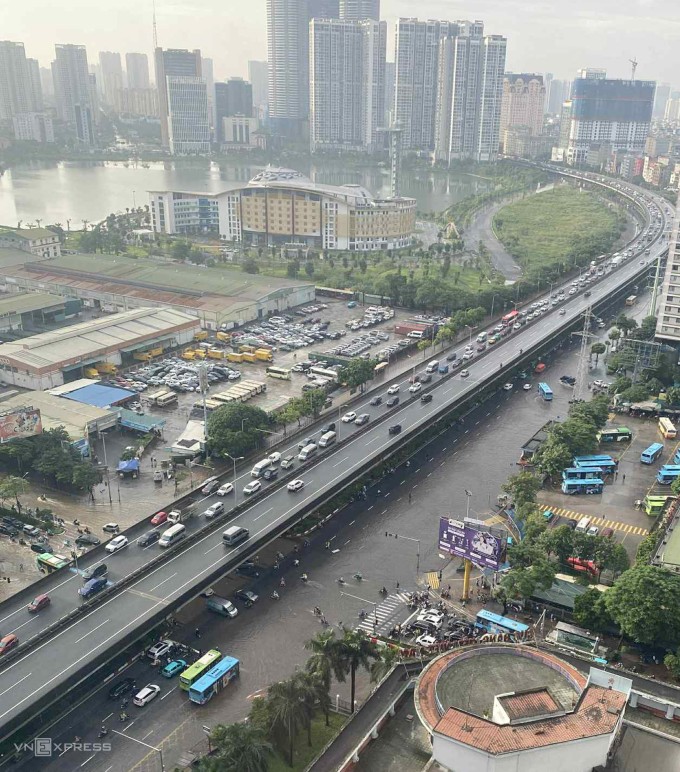 Trước bến xe Mỹ Đình vẫn còn ngập sâu, dòng xe di chuyển trên cao bắt đầu đổ về trung tâm Hà Nội lúc 7h sáng. Ảnh: Hoàng Long