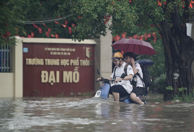 Học sinh Hà Nội tan trường trong cơn mưa lớn, đường ngập sâu, trưa 30/9. Ảnh: Hoàng Giang