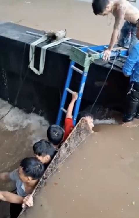 Nhiều người ngăn nước chảy vào hầm nhà số 44 Liễu Giai. Ảnh cắt từ video.