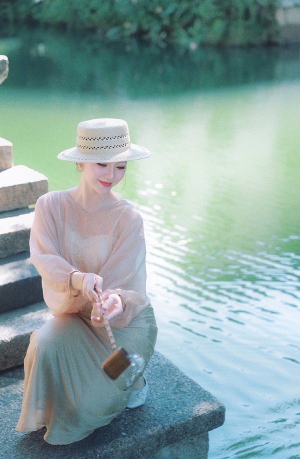 Có lúc, cô nàng lại biến hóa thành nàng thơ với style đầm dài sát gót với gam màu nude cùng mũ điệu đà.