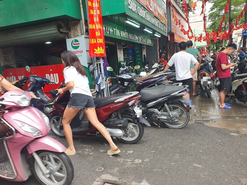 Cửa hàng sửa xe máy trên phố Khâm Thiên đông như hội, không còn chỗ để xe nên nhiều người phải dắt xe tìm nơi khác sửa hoặc mang về.