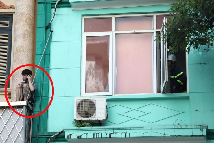 Nam thanh niên ngồi ở lan can tầng 2 ngôi nhà.