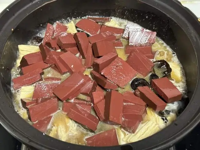 Cho mộc nhĩ và tiết heo vào nồi.