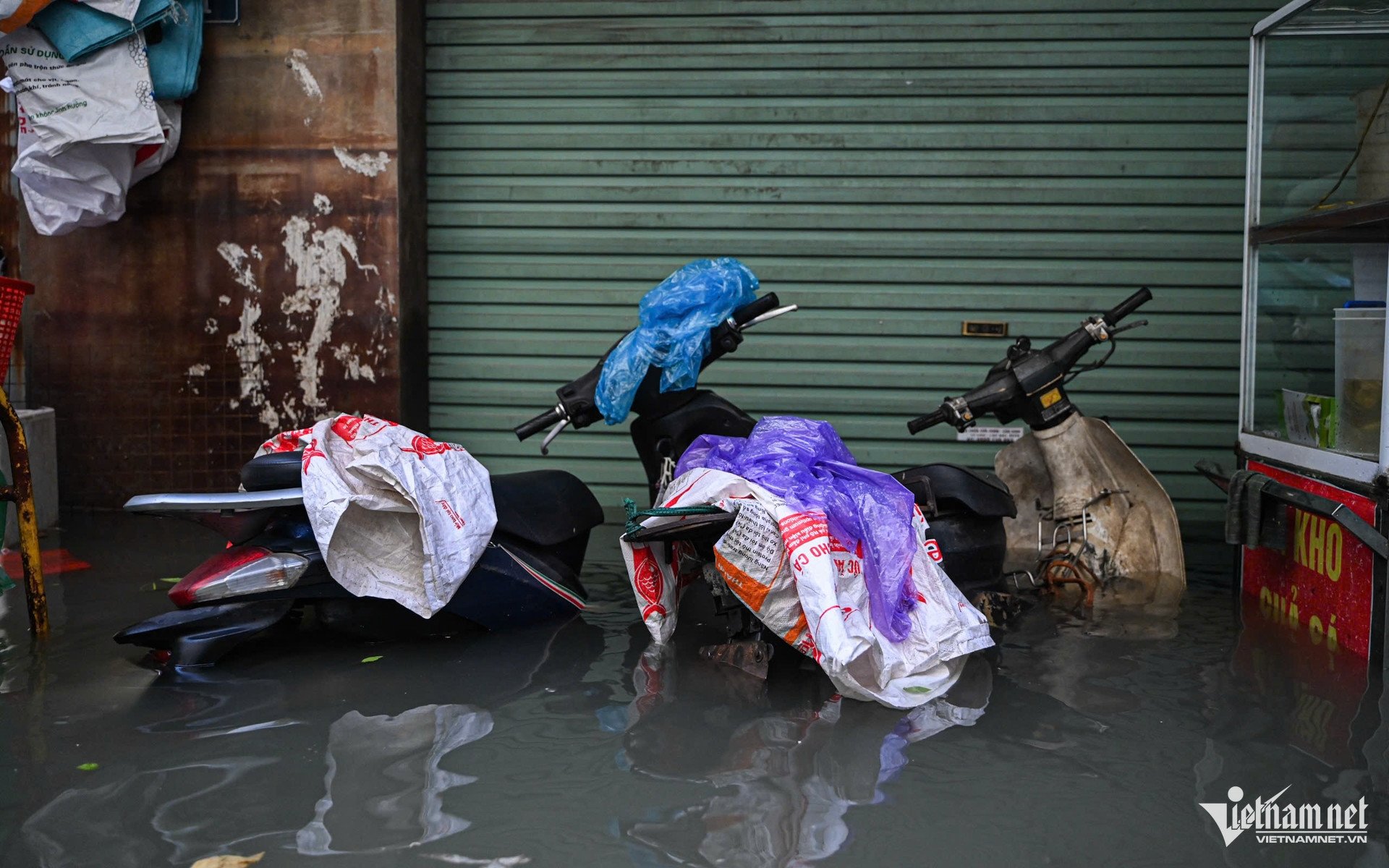 Xe máy đã được kéo tới chỗ cao nhưng vẫn "chìm nổi" trong biển nước. Ảnh: Huy Nguyễn