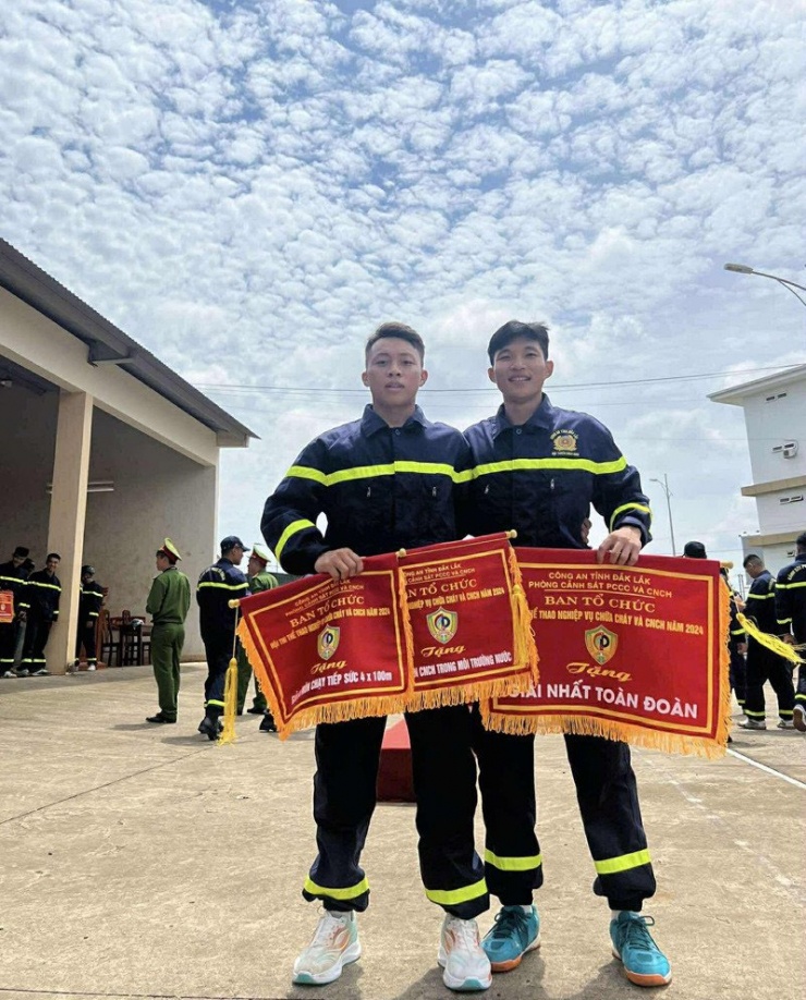 Bảo Khanh (bên trái) chụp ảnh cùng đồng đội trong trang phục lính cứu hỏa. Ảnh: NVCC