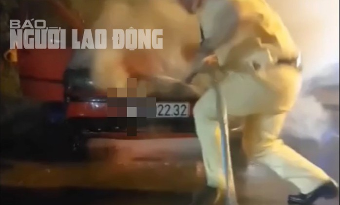 Lực lượng CSGT tỉnh Tây Ninh đưa đôi nam nữ ra khỏi chiếc xe bị cháy và khẩn trương dập lửa. Ảnh cắt ra từ clip