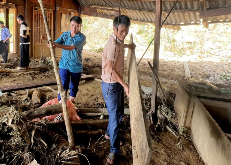 Anh Giàng A Rình (áo xanh) hỗ trợ người dân khắc phục hậu quả sau cơn bão. Ảnh: Thanh Chi.